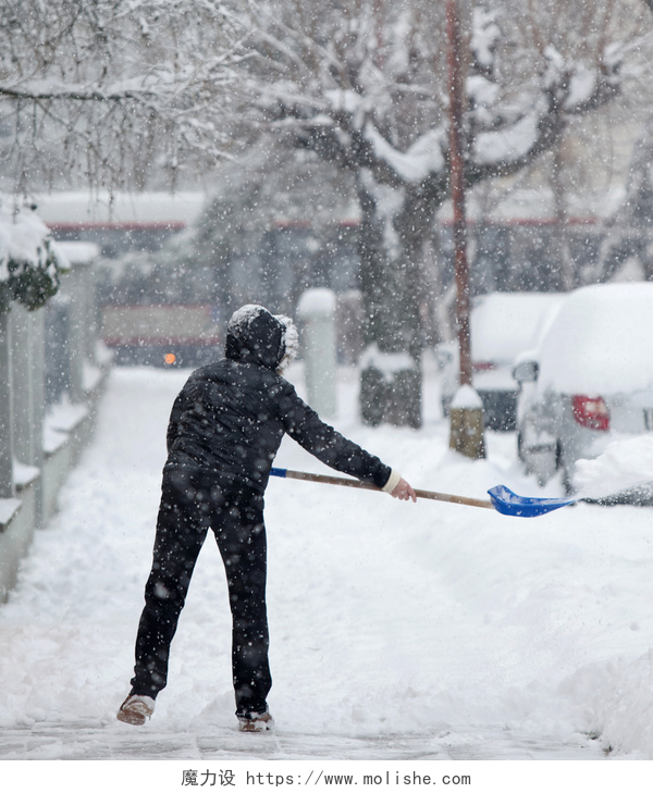 女人在道路上铲雪在大雪后铲雪从人行道上的女人